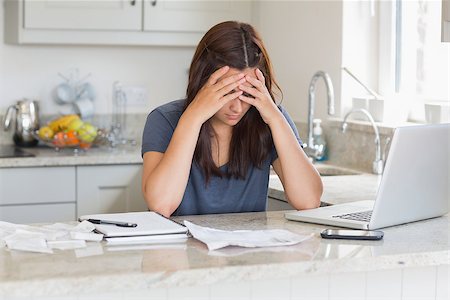 simsearch:400-06803524,k - Stressed woman looking down at bills in kitchen Stock Photo - Budget Royalty-Free & Subscription, Code: 400-06803677