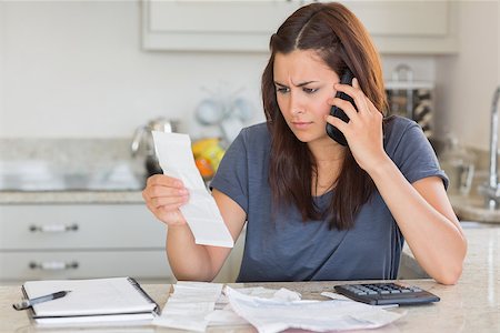 simsearch:400-06803524,k - Woman calling while calculating bills in kitchen Stock Photo - Budget Royalty-Free & Subscription, Code: 400-06803678