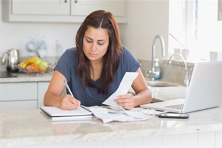 simsearch:400-06803524,k - Woman calculating receipts with laptop in kitchen Stock Photo - Budget Royalty-Free & Subscription, Code: 400-06803673