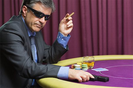 simsearch:400-06802091,k - Man with gun at poker table in casino Stock Photo - Budget Royalty-Free & Subscription, Code: 400-06803758