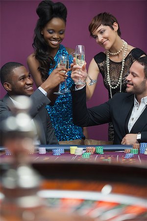 People clinking glasses at roulette table in casino Foto de stock - Super Valor sin royalties y Suscripción, Código: 400-06803780