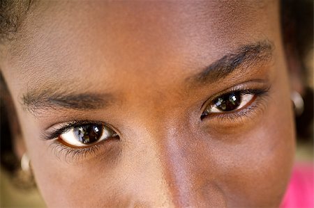 Closeup of eyes of pretty happy young african girl looking at camera and smiling Stock Photo - Budget Royalty-Free & Subscription, Code: 400-06854114