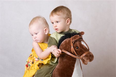 two children playing with a toy horse together Foto de stock - Super Valor sin royalties y Suscripción, Código: 400-06857497