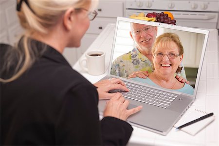 simsearch:400-06857713,k - Woman In Kitchen Using Laptop - Online Chat with Senior Couple or Parents On Screen. Fotografie stock - Microstock e Abbonamento, Codice: 400-06857714