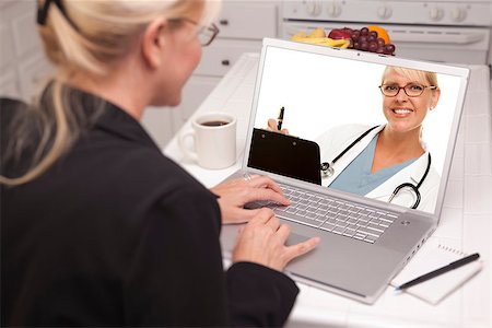 simsearch:400-06857713,k - Woman In Kitchen Using Laptop - Online Chat with Nurse or Doctor on Screen. Fotografie stock - Microstock e Abbonamento, Codice: 400-06857712