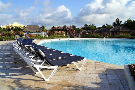 simsearch:400-06947087,k - Plank beds and chaise lounges nearby on territories of the pool, a palm tree and other structures in a recreation area Stock Photo - Budget Royalty-Free & Subscription, Code: 400-06858517