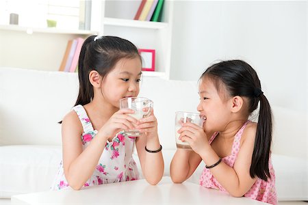 simsearch:400-04218582,k - Children drinking milk. Asian family at home. Beautiful sister drinks milk together. Stockbilder - Microstock & Abonnement, Bildnummer: 400-06858927