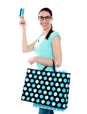 Smiling attractive woman holding cerdit-card with shopping bags wearing eyeglasses Stock Photo - Budget Royalty-Free & Subscription, Code: 400-06859104