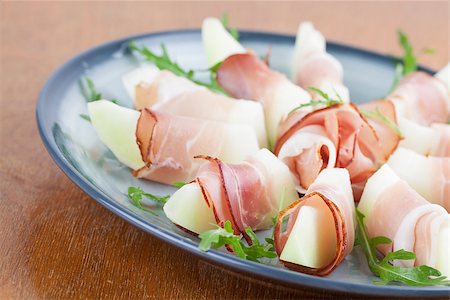 smoked ham - Prosciutto and honeydew melon appetizers with arugula Foto de stock - Super Valor sin royalties y Suscripción, Código: 400-06859702
