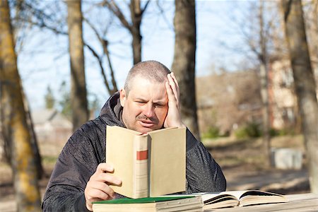 Man reading a book outdoors on a bench in the park Foto de stock - Royalty-Free Super Valor e Assinatura, Número: 400-06851627