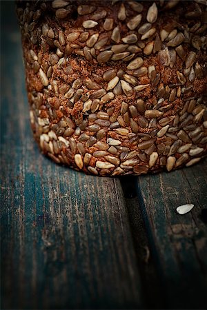 simsearch:400-06416084,k - Rustic loaf of bread with sunflower seeds on wood background Photographie de stock - Aubaine LD & Abonnement, Code: 400-06852717