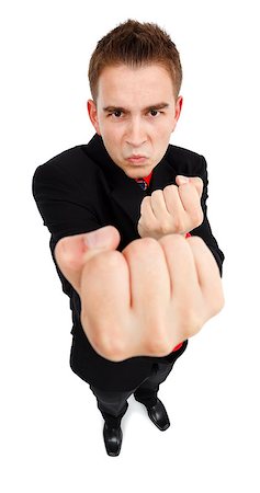 Wide angle view of an aggressive young man, showing fist, he wants to fight Foto de stock - Super Valor sin royalties y Suscripción, Código: 400-06853424