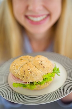 simsearch:400-06929112,k - Closeup on plate with sandwich in hand of smiling teenager girl Foto de stock - Royalty-Free Super Valor e Assinatura, Número: 400-06853553