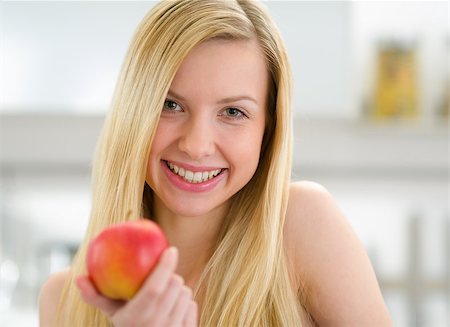 Portrait of smiling teenager girl with apple in kitchen Stock Photo - Budget Royalty-Free & Subscription, Code: 400-06853563