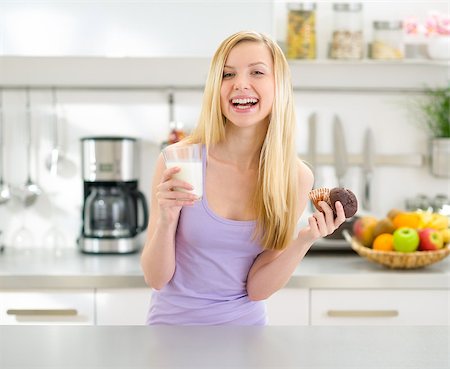 simsearch:400-04540771,k - Happy teenager girl eating chocolate muffin with milk Fotografie stock - Microstock e Abbonamento, Codice: 400-06853574