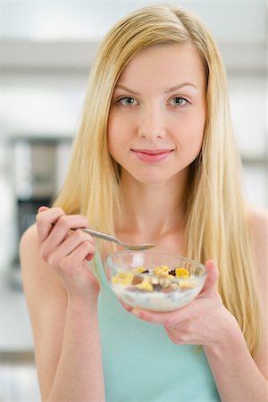 Teenager girl eating flakes with milk in kitchen Stock Photo - Budget Royalty-Free & Subscription, Code: 400-06853577