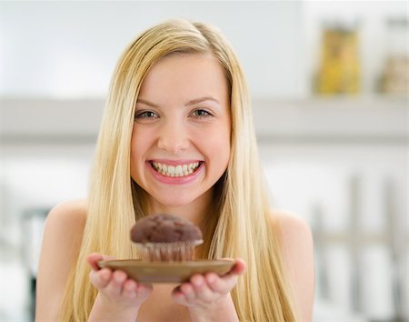 Smiling teenager girl showing chocolate muffin Stock Photo - Budget Royalty-Free & Subscription, Code: 400-06853571