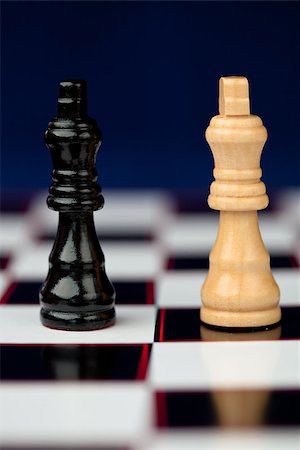 simsearch:640-03260635,k - Black and white chess pieces standing at the chessboard against blue background Stock Photo - Budget Royalty-Free & Subscription, Code: 400-06864286