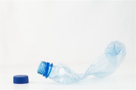 Empty plastic bottle crushed and blue cap to recycle Stock Photo - Budget Royalty-Free & Subscription, Code: 400-06864359