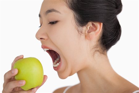 fresh-faced - Woman biting into a green apple Stock Photo - Budget Royalty-Free & Subscription, Code: 400-06864598