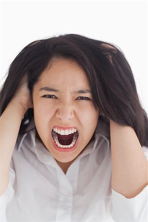 person screaming pulling hair - Screaming brunette pulling her hair on white background Stock Photo - Budget Royalty-Free & Subscription, Code: 400-06864623