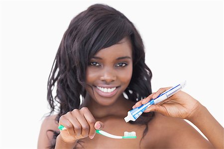 Woman holding a toothbrush and toothpaste against white background Stock Photo - Budget Royalty-Free & Subscription, Code: 400-06865096