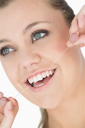 Woman using dental floss in the white background Stockbilder - Microstock & Abonnement, Bildnummer: 400-06865325
