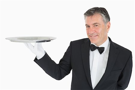 plateau d'argent - Waiter holding a silver tray and smiling Photographie de stock - Aubaine LD & Abonnement, Code: 400-06865466