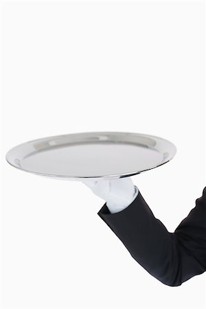 White gloved hand holding a silver tray in front of camera Fotografie stock - Microstock e Abbonamento, Codice: 400-06865469