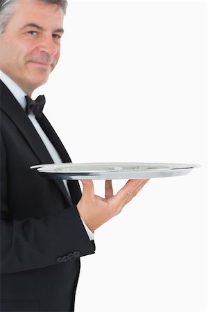 Waiter holding a silver tray with his hand on white background Fotografie stock - Microstock e Abbonamento, Codice: 400-06865487