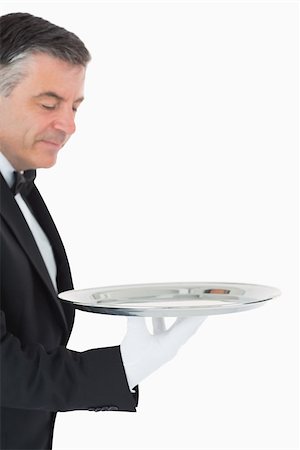silver service - Waiter looking and holding a silver tray in front of camera Stock Photo - Budget Royalty-Free & Subscription, Code: 400-06865489