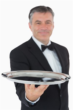 Cheerful waiter holding a silver tray in front of camera Fotografie stock - Microstock e Abbonamento, Codice: 400-06865483