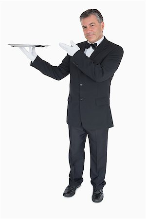 Happy waiter presenting an empty silver tray Fotografie stock - Microstock e Abbonamento, Codice: 400-06865604