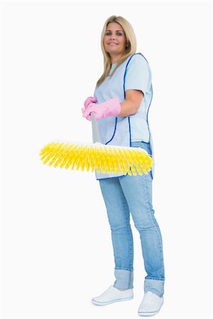 simsearch:400-06866097,k - Smiling cleaner woman holding a yellow broom in the white background Foto de stock - Super Valor sin royalties y Suscripción, Código: 400-06866093