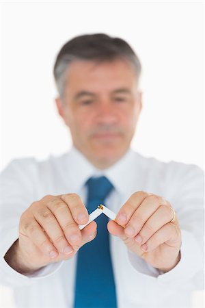 Man concentrating on breaking cigarette in half Stock Photo - Budget Royalty-Free & Subscription, Code: 400-06866385