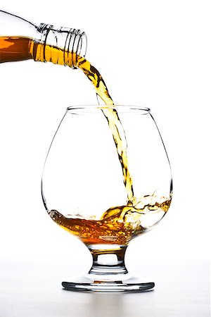 cognac pour into the glass over white background Foto de stock - Super Valor sin royalties y Suscripción, Código: 400-06867065