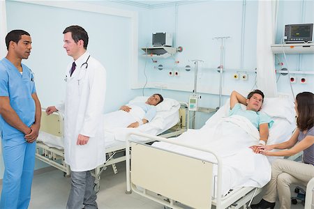 simsearch:400-06800658,k - Doctor and male nurse in a hospital room with patient resting Stock Photo - Budget Royalty-Free & Subscription, Code: 400-06867985