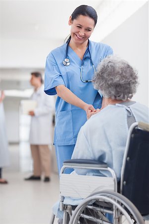 simsearch:400-07337135,k - Doctor greeting recovering senior patient in wheelchair in a hospital corridor Stock Photo - Budget Royalty-Free & Subscription, Code: 400-06867981