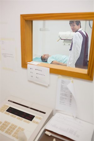 View of doctor doing a radiography through a window in an examination room Stock Photo - Budget Royalty-Free & Subscription, Code: 400-06868040