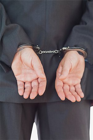 simsearch:400-06868559,k - Rear view of businessman in suit with handcuffs Fotografie stock - Microstock e Abbonamento, Codice: 400-06868550