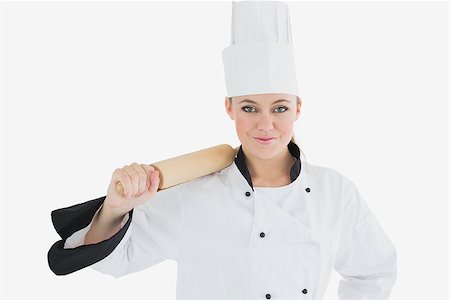 rolling over - Portrait of female chef holding rolling pin over white background Photographie de stock - Aubaine LD & Abonnement, Code: 400-06868609