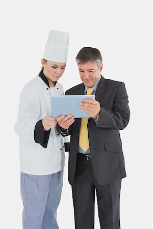 Female chef and businessman using digital tablet over white background Stock Photo - Budget Royalty-Free & Subscription, Code: 400-06868659