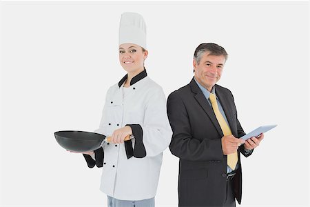 simsearch:400-07953213,k - Portrait of businessman holding digital tablet and female chef with frying pan over white background Foto de stock - Super Valor sin royalties y Suscripción, Código: 400-06868669