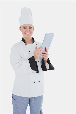 Portrait of happy female chef holding digital tablet over white background Stock Photo - Budget Royalty-Free & Subscription, Code: 400-06868681