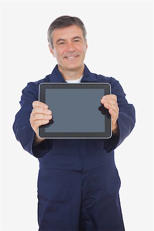 Mature mechanic showing digital tablet over white background Photographie de stock - Aubaine LD & Abonnement, Code: 400-06868700