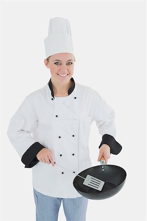 simsearch:400-07953213,k - Portrait of happy female chef using spetula and frying pan over white background Foto de stock - Super Valor sin royalties y Suscripción, Código: 400-06868717