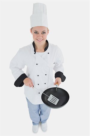 High angle view of female chef with spatula and frying pan over white background Stock Photo - Budget Royalty-Free & Subscription, Code: 400-06868718