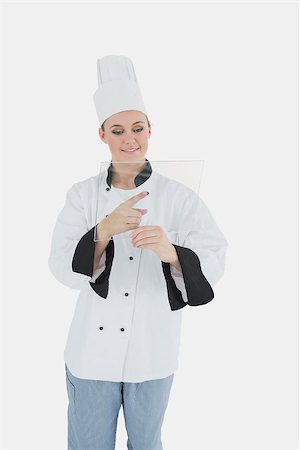 Young female chef using glass tablet over white background Stock Photo - Budget Royalty-Free & Subscription, Code: 400-06868729