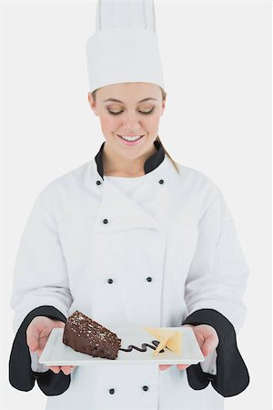 pastry chef uniform for women - Happy young female chef holding plate of pastry over white background Stock Photo - Budget Royalty-Free & Subscription, Code: 400-06868770
