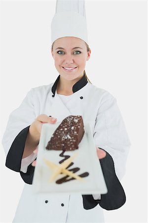 pastry chef uniform for women - Portrait of young female chef offering pastry over white background Stock Photo - Budget Royalty-Free & Subscription, Code: 400-06868773